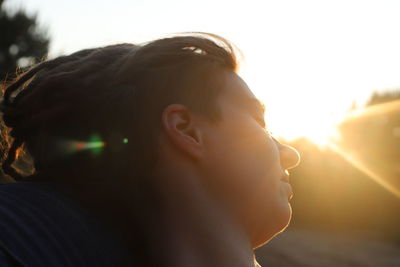 Close-up portrait of woman against sky during sunset