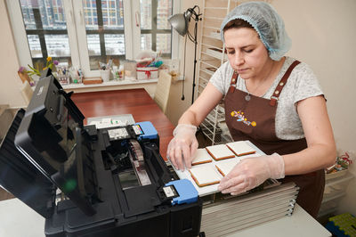 Side view of young woman working at home