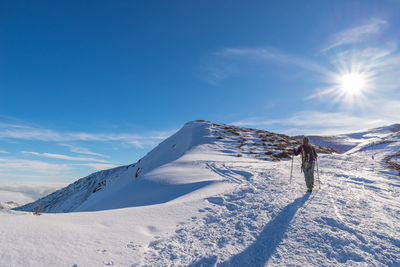 Rear view of woman with backpack on snow covered landscape