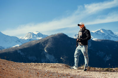 Man standing on mountain against sky