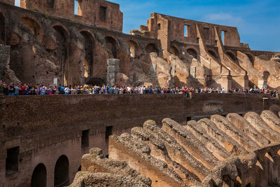 Tourists visiting the interior of the famous colosseum in rome