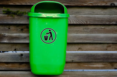 Close-up of green can on wooden wall