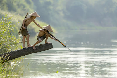 Traditional fishing on lake against plants