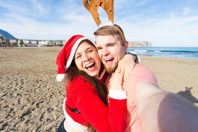 Portrait of smiling young couple on beach