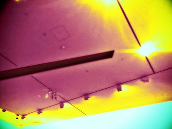 Low angle view of illuminated lighting equipment against sky