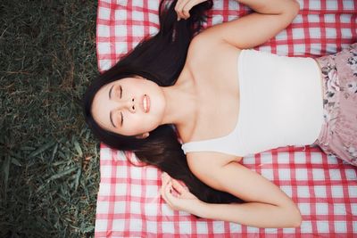 Directly above shot of woman lying on picnic carpet