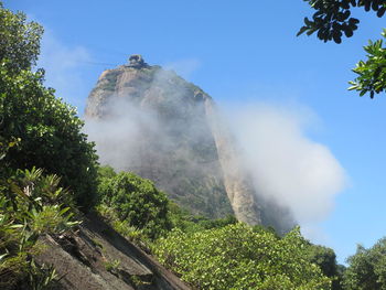 Low angle view of sugarloaf mountain with clouds against sky