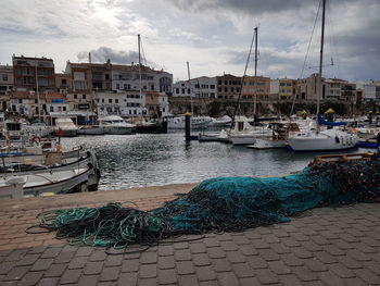 Boats moored at harbor against sky