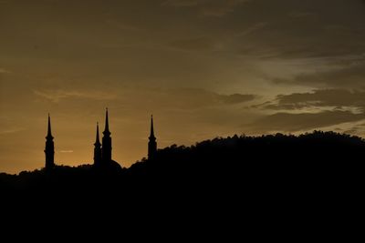 Silhouette of temple building against sky during sunset