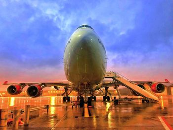 Airplane on airport runway against sky