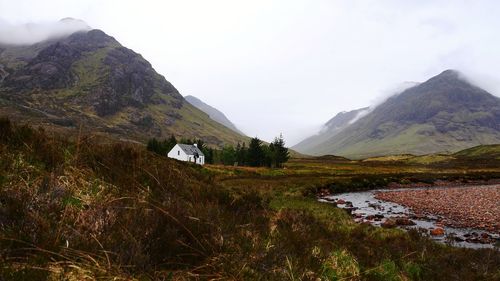Scenic view of field and mountains against sky