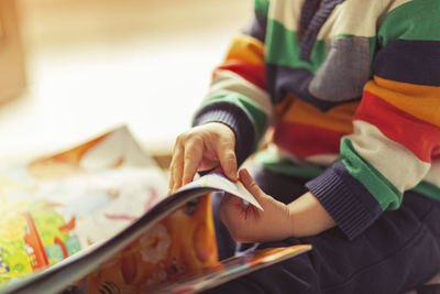 Midsection of child holding book