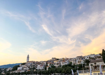 View of buildings in town against cloudy sky