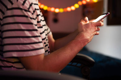 Midsection of man using mobile phone