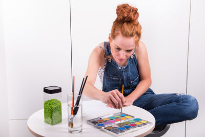 Woman painting while sitting at home