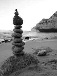 Stack of pebbles on beach against clear sky