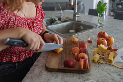 Midsection of woman cuttin  food