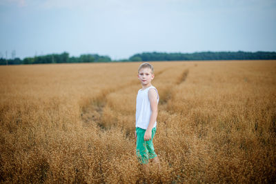 Full length of girl standing on field against sky