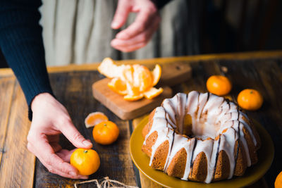 High angle view of orange fruits and glazed cake on table