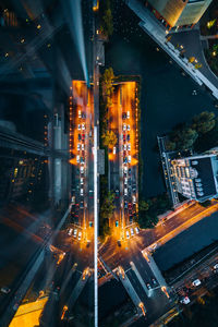 High angle view of illuminated street amidst buildings at night