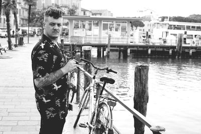 Portrait of young man standing by waterfront