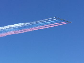 Low angle view of airshow against clear blue sky