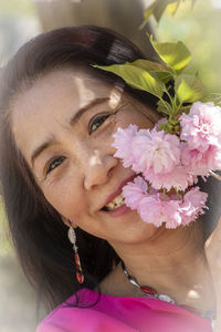 Close-up portrait of woman with pink flower