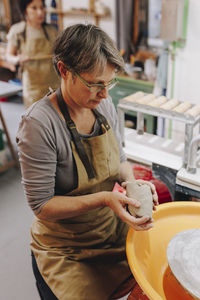 Potter with clay working at ceramics workshop