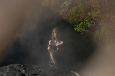 Portrait of young woman on rock