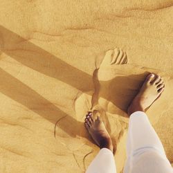 Low section of woman on sand at beach