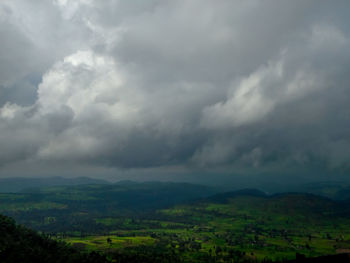 Scenic view of landscape against storm clouds
