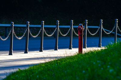 Metal railing on field by sea