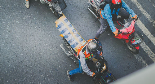 Low section of people riding motorcycle on road