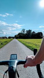 Man riding bicycle on road against sky