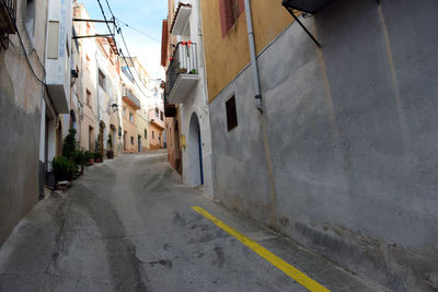 Road amidst buildings against sky