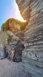 Woman standing against cliff