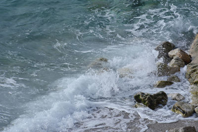 High angle view of waves splashing on rocks