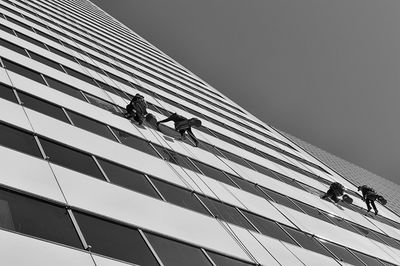 Low angle view of men working against sky