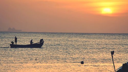 Silhouette boat in sea against sky during sunset