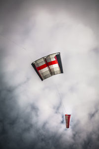 Low angle view of kite flying against cloudy sky