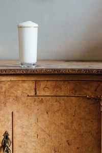 White ramos gin fizz milkshake with foam on burl wood table 