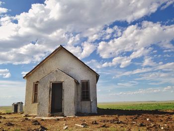 Old house on field against sky