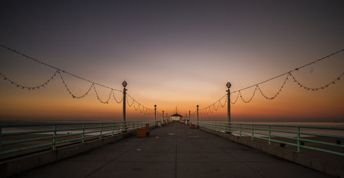 Bridge over sea against sky during sunset