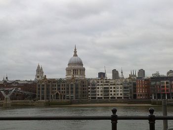 Buildings in city against cloudy sky