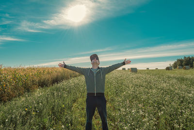 Rear view of man standing on field against sky