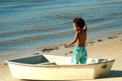 Full length of shirtless boy on beach