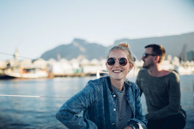 Portrait of smiling young woman against sky