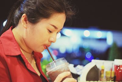 Close-up portrait of woman drinking glass at restaurant