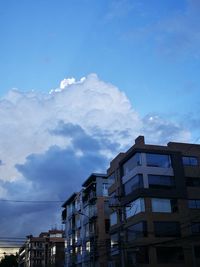 Low angle view of apartment building against blue sky