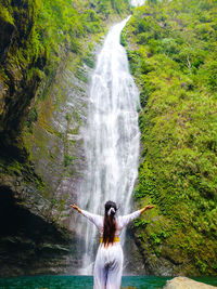 Rear view of woman looking at waterfall